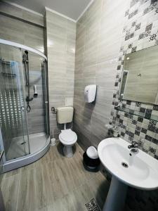 a bathroom with a sink and a toilet and a shower at Hotel Suprem in Băile Olăneşti