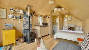 a dog is sitting in a room with a bedroom at St Aidan Beach Hut in Alnmouth