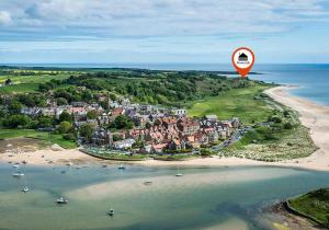 an aerial view of a town on a beach with a sign at St Aidan Beach Hut in Alnmouth