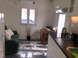 uma cozinha e sala de estar com um sofá verde em Lovers House em Setúbal