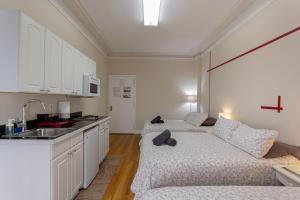 Studio Plus - Cozy Apartments في نيويورك: مطبخ بسريرين واريكة في الغرفة