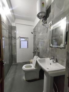 y baño con aseo blanco y lavamanos. en Jain Homestay, en Darjeeling