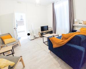 sala de estar con sofá azul y TV en Artbleu -Tout Confort - Idéal Pros - Proche commerces, en Montluçon