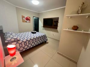 1 dormitorio pequeño con 1 cama y TV en Suite Junior Urdesa Central., en Guayaquil