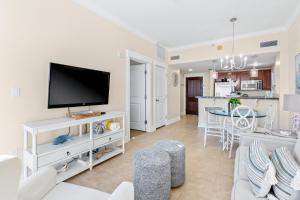 a living room with a tv and a kitchen at The Grand 2803 in Destin