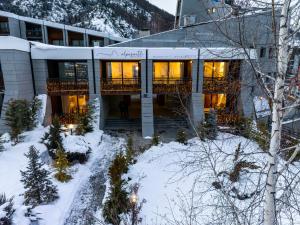 a building in the snow with lights on at Alpesmith - Bike & Ski apartments in Bardonecchia