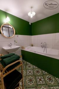 a green bathroom with a tub and a sink at CHAMBRES D'HÔTES L'Oréliane en Provence SPA in Châteauneuf-de-Gadagne +33 photos