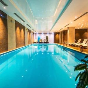 a large swimming pool in a hotel room at Orbi Palace Bakuriani Apartment in Bakuriani