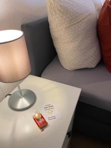 una lámpara en una mesa junto a una cama en Gasthaus Zur Post en Uetze