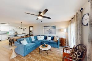 a living room with a blue couch and a kitchen at Cotton Bayou B1 in Orange Beach