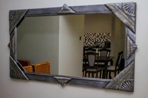 a mirror hanging on a wall with a dining room at House Samaika in Maun