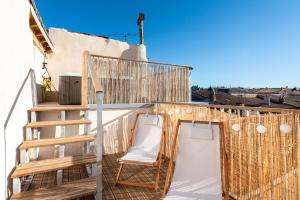 - un balcon avec deux chaises et une échelle dans l'établissement Les Clés de Laure - Le 11 JACUZZI avec Terrasses Clim Netflix Parking, à Carcassonne