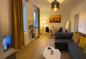 a living room with a blue couch and a tv at Gasthaus Zur Post in Uetze