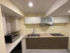 a small kitchen with a sink and a microwave at Beautiful Unit in Nepean Ottawa in Ottawa