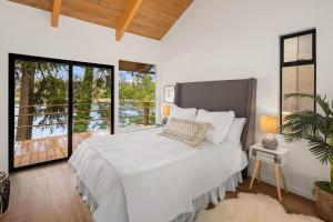 a bedroom with a white bed with a large window at Agate Bridge Beauty in Agate Point