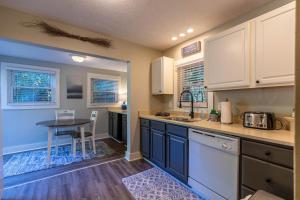 a kitchen with white cabinets and a table in it at Hot Toddy Cottage in Banner Elk
