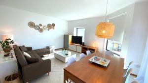 uma sala de estar com uma mesa e uma sala de estar com um sofá em Pleno Beach-side apartment Furadouro no Furadouro