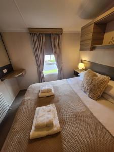 ein Schlafzimmer mit einem großen Bett mit zwei Handtüchern darauf in der Unterkunft Seton Sands Holiday Home in Port Seton