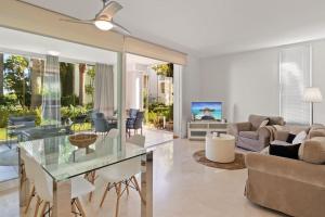 ein Wohnzimmer mit einem Glastisch und einem Sofa in der Unterkunft Alcazaba Lagoon modern flat Ref M14 in Estepona