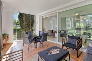 ein Wohnzimmer mit einem Tisch und Stühlen in der Unterkunft Alcazaba Lagoon modern flat Ref M14 in Estepona