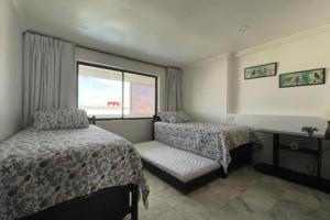 圣安德烈斯Apartamento con Vista al Mar en Sun Rise San Andrés的有两张床和一扇窗户的酒店房间