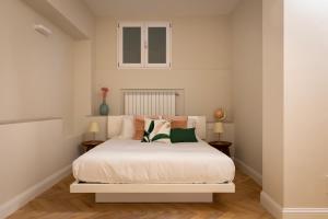 1 Schlafzimmer mit einem weißen Bett und 2 Tischen in der Unterkunft Castore Apartment in Mailand