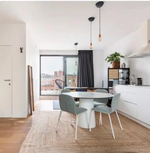 een keuken en eetkamer met een tafel en stoelen bij New apartment with big terrace and great views! in Leuven