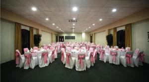 a room filled with tables and chairs with pink bows at Hotel Oaxaca Dorado in Oaxaca City