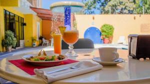 a table with a plate of food and a drink at Hotel Oaxaca Dorado in Oaxaca City