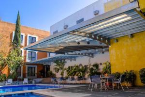 a patio with a table and chairs and a pool at Hotel Oaxaca Dorado in Oaxaca City