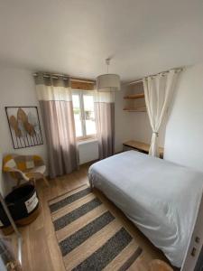 um quarto com uma cama branca e uma janela em Villa avec jacuzzi proche de la mer et du centre em Barbâtre