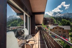 翁根Alpenkräuter Hotel Bären的阳台配有桌椅,享有山景。