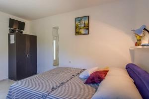1 dormitorio con 1 cama y una foto en la pared en Ivka 2, en Mali Lošinj
