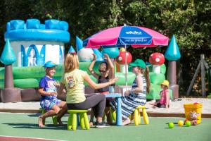 een groep kinderen aan een tafel in een speeltuin bij Camping Officiel Siblu Domaine de Soulac in Soulac-sur-Mer