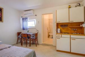 a room with a kitchen and a table and a room with a bathroom at Ivka 2 in Mali Lošinj