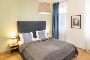 een slaapkamer met een groot bed en blauwe gordijnen bij Jimmy's Apartments Dandelion in Wenen