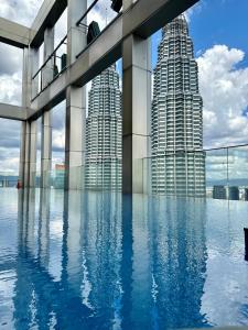a pool in front of two tall buildings at Tropicana Residence Klcc @ Roof Top Swimming Pool in Kuala Lumpur