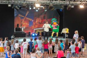 a group of children watching a man on a stage at Camping Officiel Siblu Les Pierres Couchees in Saint-Brevin-les-Pins +60 photos