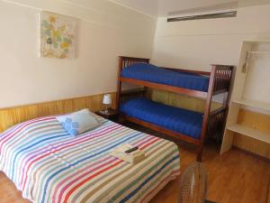 1 dormitorio con 1 cama y 1 litera azul en Palm Hostal, en Iquique