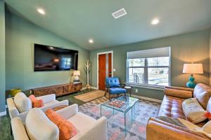 a living room with couches and a flat screen tv at Modern Bentonville Home Mountain Bikers Paradise in Bentonville