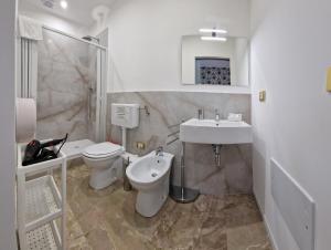 a white bathroom with a toilet and a sink at PANORAMICO in Catania