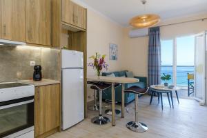 een keuken met een koelkast en een tafel met stoelen bij BigBlue luxury apartments in Póros