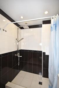 a bathroom with a shower with black and white tiles at 19Tumanyan Excellent apartment in the centre of capital in Yerevan