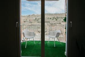 a view of a balcony with two chairs and a table at tuGuest Carretera de la Sierra Apartment in Granada