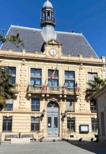 budynek z wieżą zegarową na górze w obiekcie studio climatisé proche de Montpellier et des plages w mieście Villeneuve-lès-Maguelone