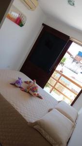 uma cama com um bicho de peluche sentado em cima dela em Tamandare Residence em Tamandaré