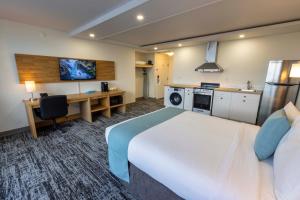 a hotel room with a large bed and a desk at Highliner Hotel in Prince Rupert