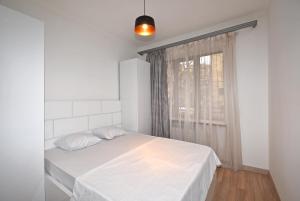a white bedroom with a bed and a window at 19Tumanyan Excellent apartment in the centre of capital in Yerevan