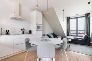 a kitchen and living room with a table and chairs at New apartment with big terrace and great views! in Leuven