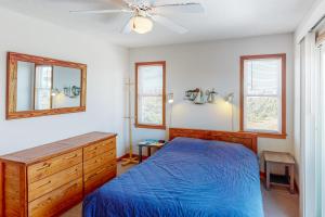 Schlafzimmer mit einem blauen Bett und einem Deckenventilator in der Unterkunft Siren's Song #D7-HC in Avon